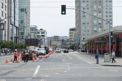 Street closure at 4th and King streets with construction equipment and workers, traffic cones blocking the roadway.