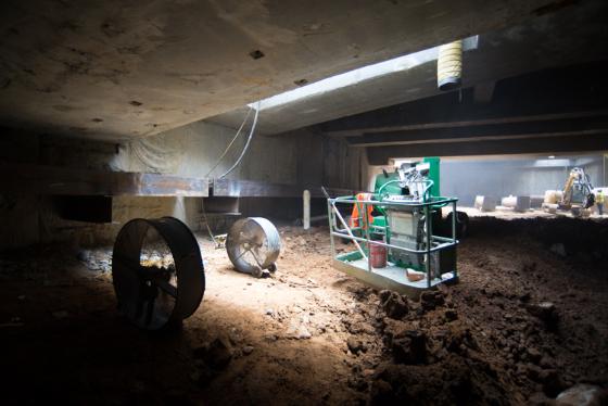 Underground construction site with excavation equipment and machinery during Central Subway tunnel work.