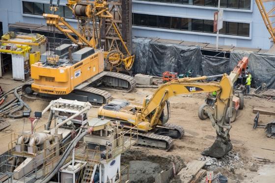 Construction equipment and crew at Yerba Buena/Moscone Station site with excavators and machinery.