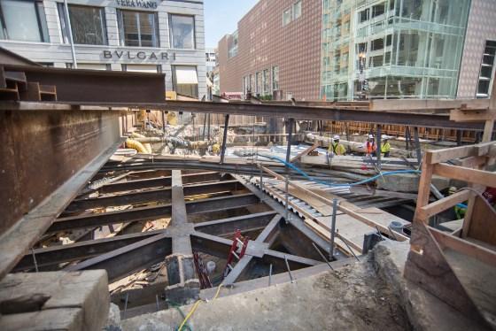 Construction site showing steel framework and PVC conduits during Market Street Station concourse roof deck installation.