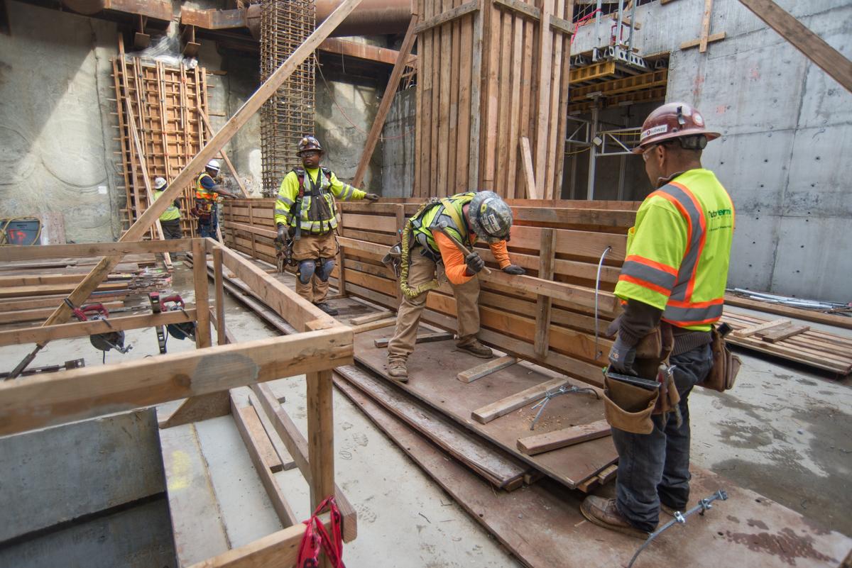 Construction workers build concrete forms for a column inside Yerba Buena/Moscone station headhouse.