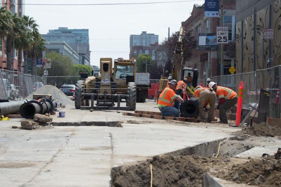 Construction workers assemble pipe sections on 4th Street for Central Subway project in San Francisco.