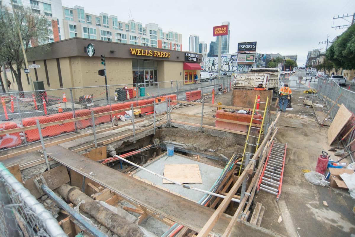 Construction excavation at 4th and Townsend with utility work, fencing, and equipment visible along street.