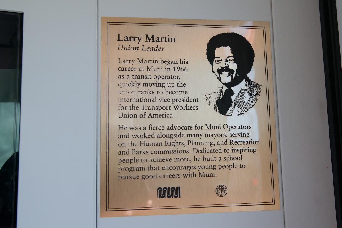 Commemorative plaque honoring Larry Martin, Union Leader, with portrait and biography text on wooden background.