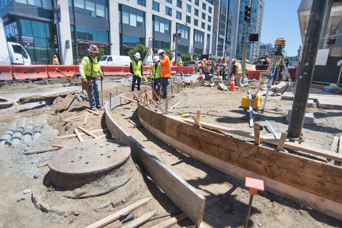 Construction workers install concrete forms for curb and bulb-out at 4th and Market Street intersection.