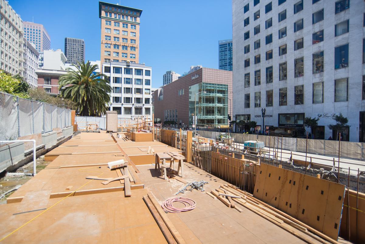 Urban construction site with wooden forms and bracing beneath downtown buildings