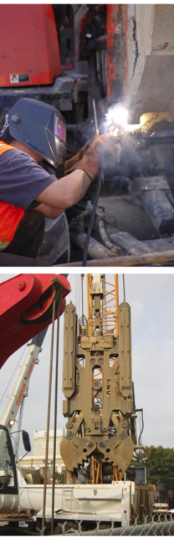 Worker welding tunnel segment; tunnel boring machine at construction site.