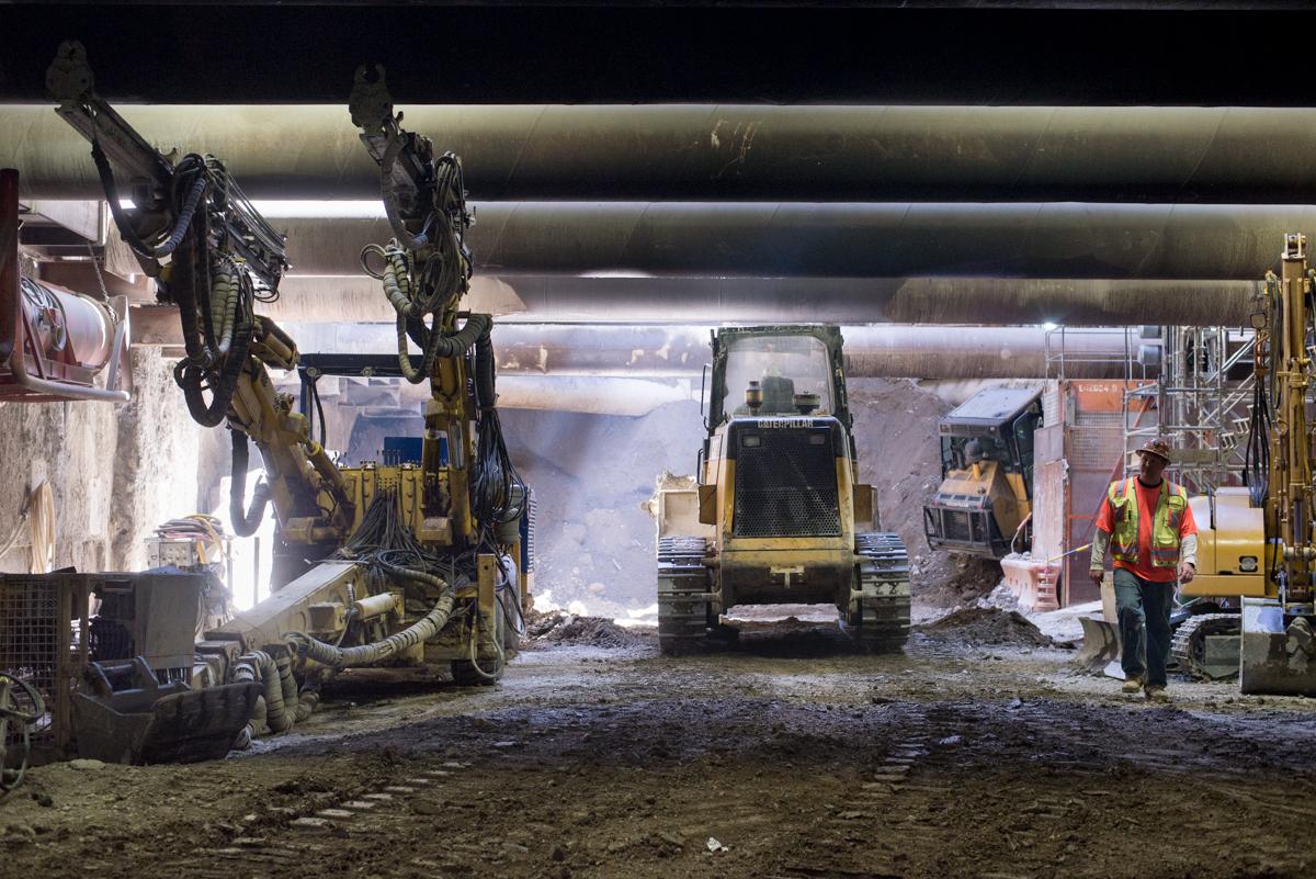 Excavation equipment and workers inside underground tunnel during sewer work on Washington Street.