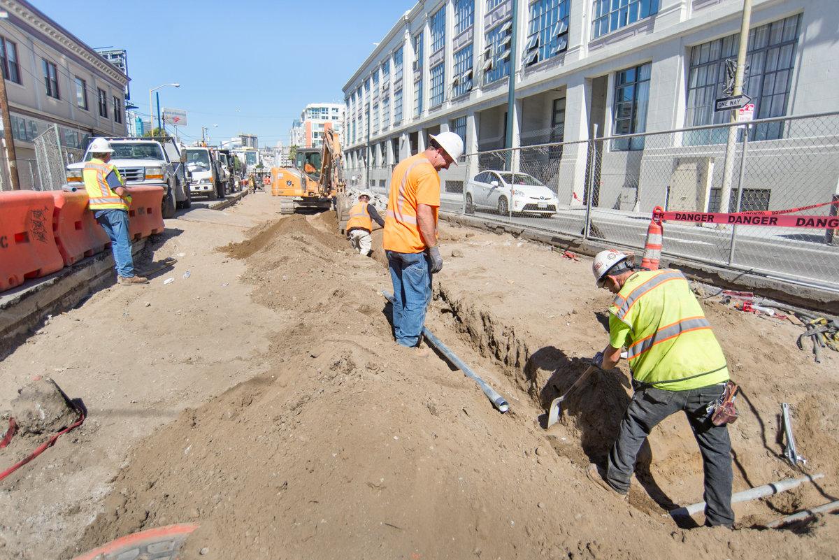 Construction workers dig trenches for electrical and signaling systems on 4th Street between Bryant and King.