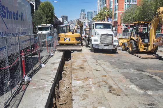 Construction equipment and trucks on 4th Street during duct bank installation in San Francisco.