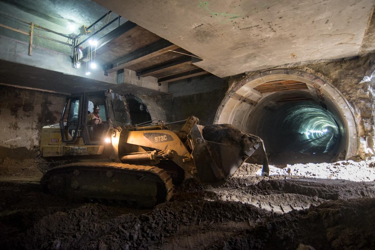 Excavator breaks through twin subway tunnel during underground station construction.