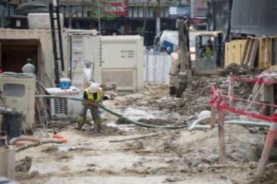 Construction workers operate drilling equipment at Geary and Stockton Street intersection for soil improvement work.