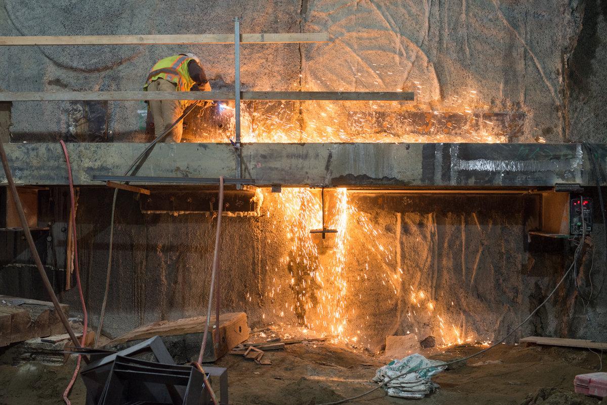 Worker welding steel beams inside Yerba Buena/Moscone station during Central Subway construction.