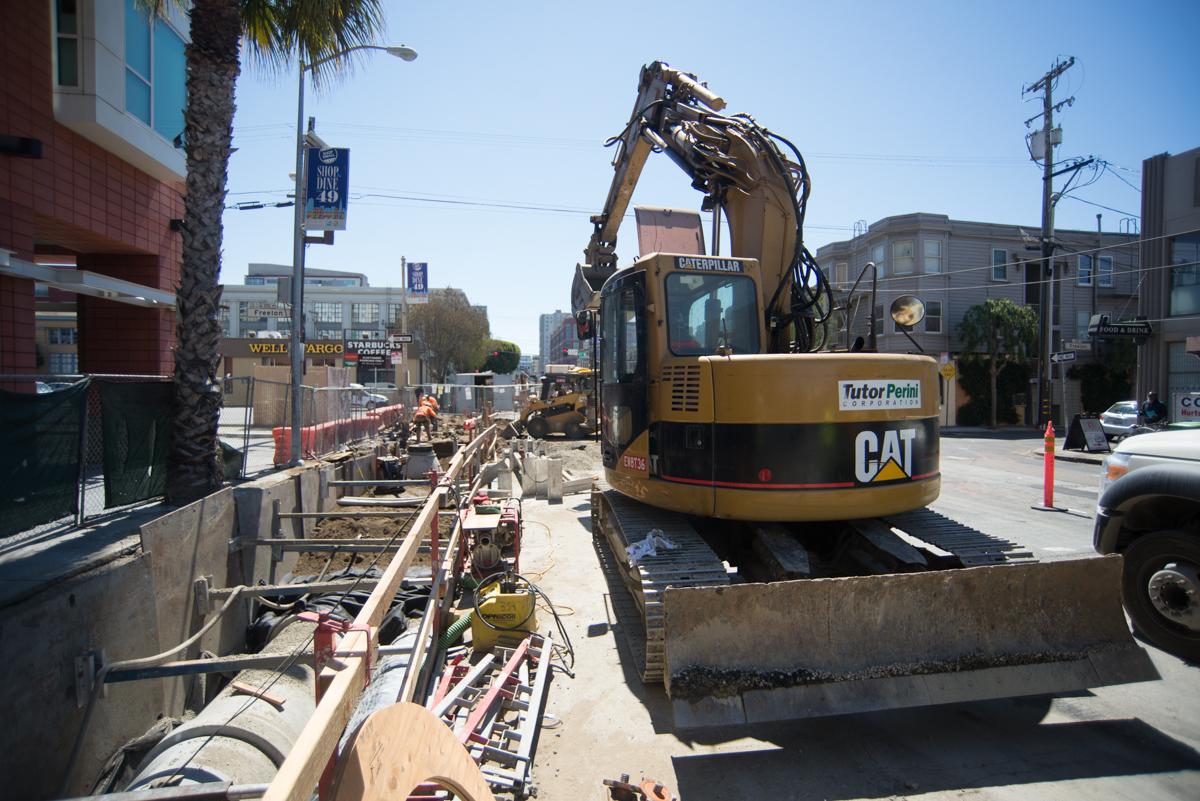 CAT excavator operates on 4th Street during Central Subway construction in San Francisco.