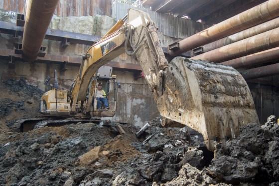 Excavator removing debris from underground transit station construction site on 4th Street.