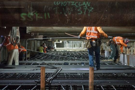 Workers install rebar framework for mezzanine level at Yerba Buena-Moscone Station.