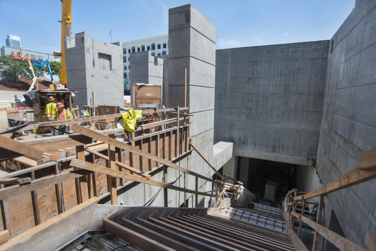 Construction site showing concrete structures and wooden stair formwork for Yerba Buena/Moscone Station entrance.