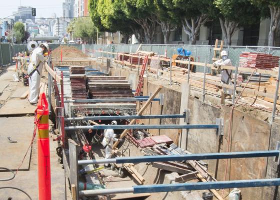 Workers construct reinforced concrete sewer roof on 4th Street construction site.