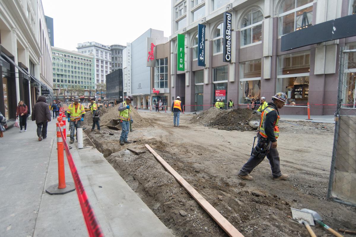 Construction crew works on underground transit project on downtown street near Union Square.