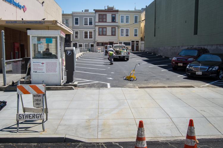 Street closure with construction equipment and traffic cones on Washington Street parking lot during fire hydrant work.
