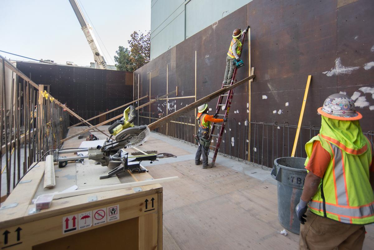 Construction workers install concrete forms and ventilation shafts at Yerba Buena/Moscone Station headhouse.