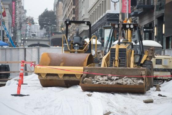 Construction equipment compacting soil on a street in downtown San Francisco.