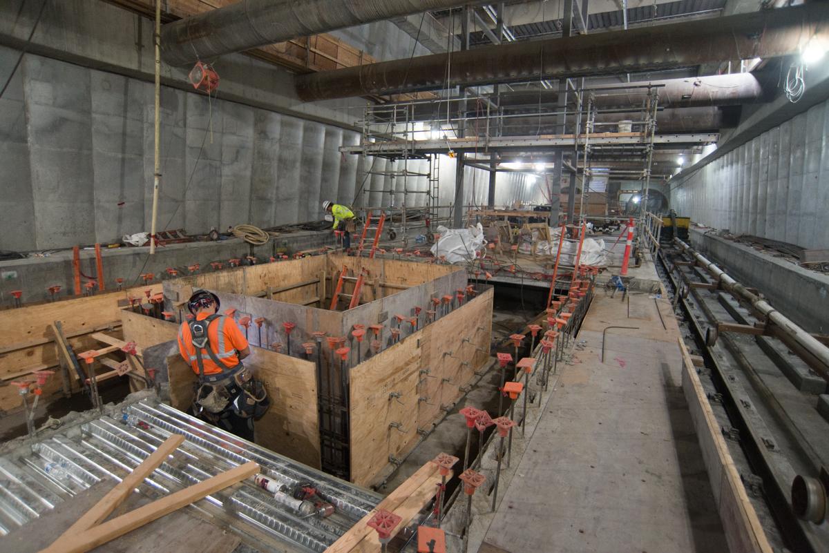 Construction workers build concrete forms and rebar cages for Union Square/Market Street project underground.