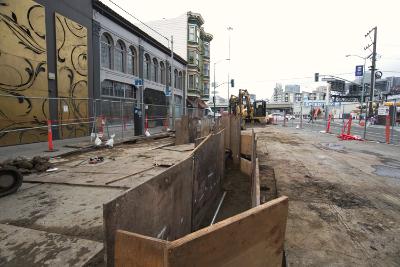 Construction crew excavates trench for Muni ductbank at 4th and King Streets intersection.