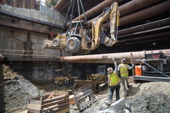 Backhoe lowered into underground station headhouse for excavation work at 4th Street and Townsend.