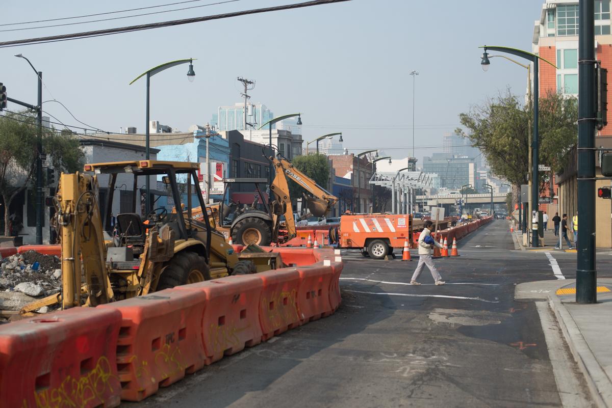 Construction equipment and barriers on city street during utility work in SoMa neighborhood.