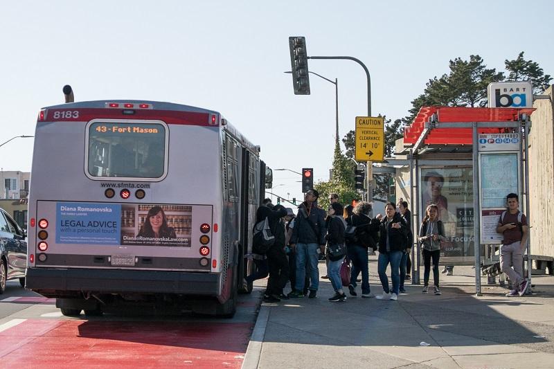 Red and white bus number 8183 stopped at transit shelter with passengers boarding, route 43 Fort Mason displayed.