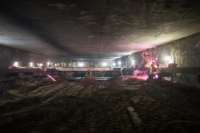 Underground construction site with temporary lighting and welding equipment at transit station headhouse.
