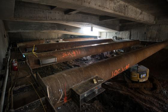Large rusted steel support beams installed inside underground transit station headhouse during construction.