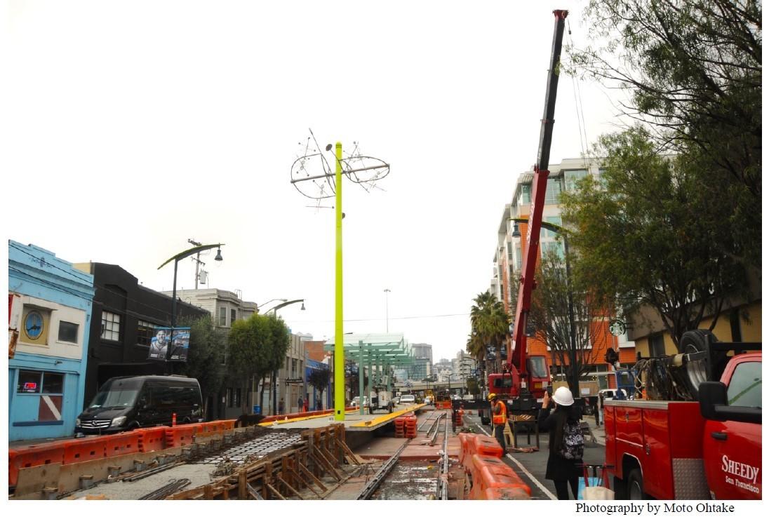 Construction work on 4th Street with utility poles, safety barriers, and equipment during street infrastructure project.