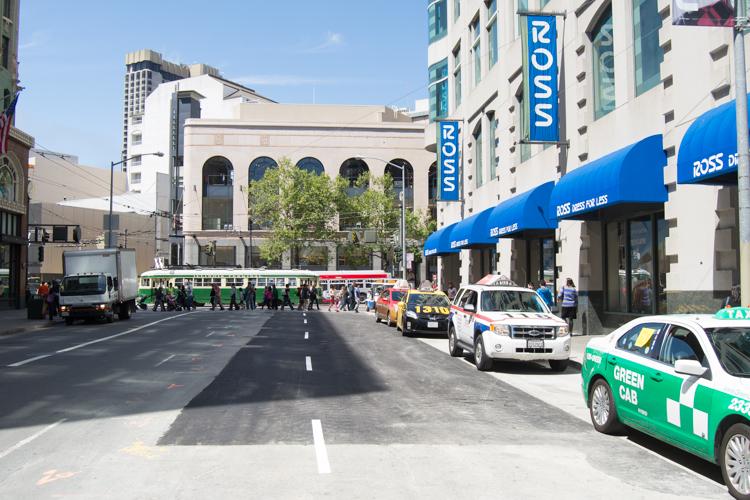 4th Street downtown with taxis, green cab, and bus on repaved street near Ross store and historic building