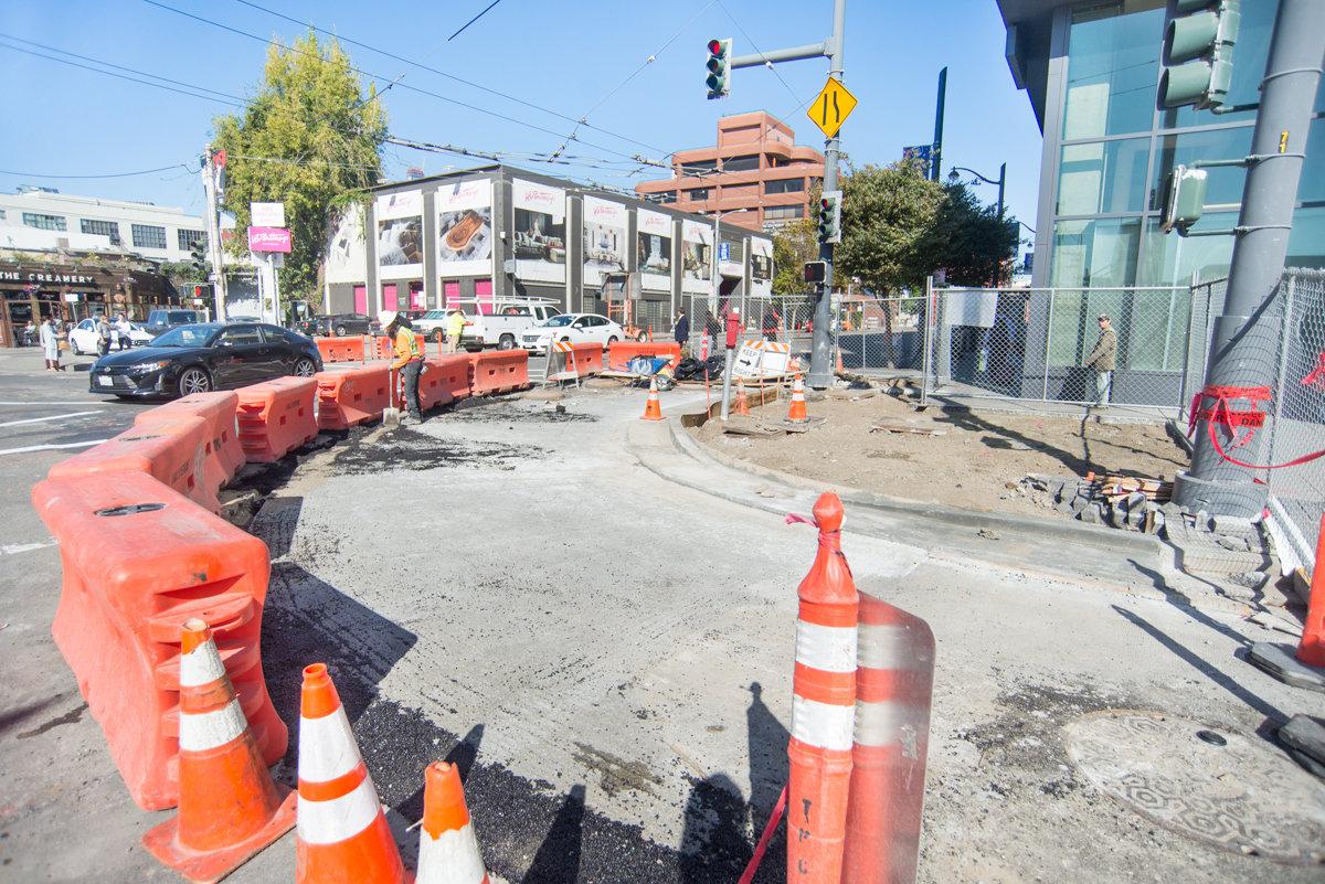 Construction site at 4th and Townsend with orange barriers, traffic cones, and new roadway being built.