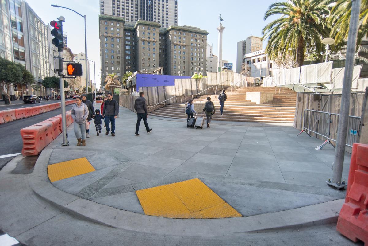 Union Square pedestrian plaza with restored sidewalk, stairs, and construction barriers during ongoing transit work.