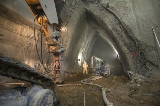 Construction workers spray shotcrete inside underground tunnel excavation for Chinatown Station.