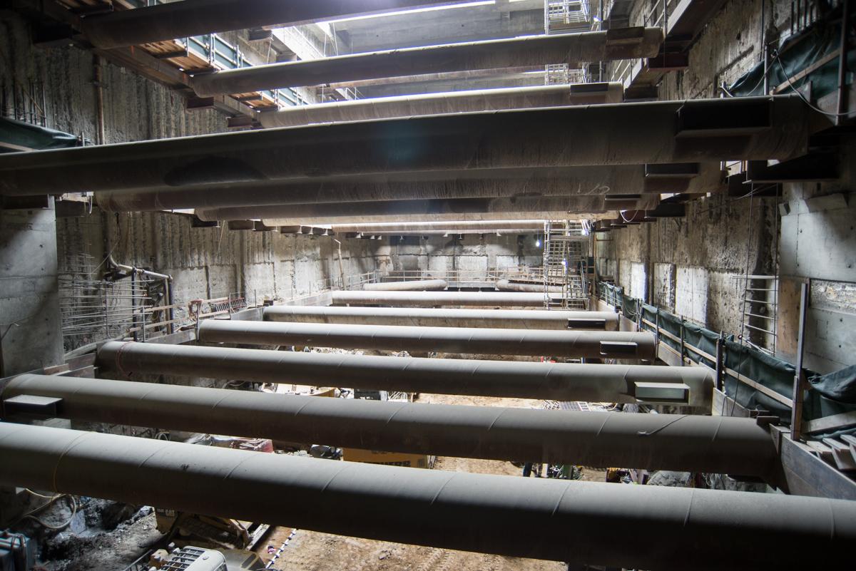Large steel support beams installed horizontally inside concrete tunnel structure during transit construction.