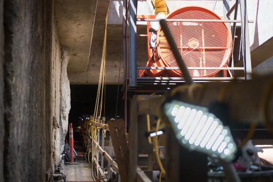 Construction site with ventilation fan and red warning light above underground work area