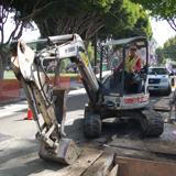 Excavator on street during Central Subway construction work on Columbus Avenue.