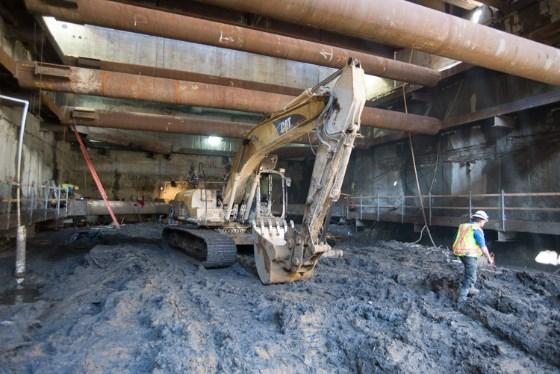 Excavator moving material inside Yerba Buena Moscone Station headhouse during sewer installation work.