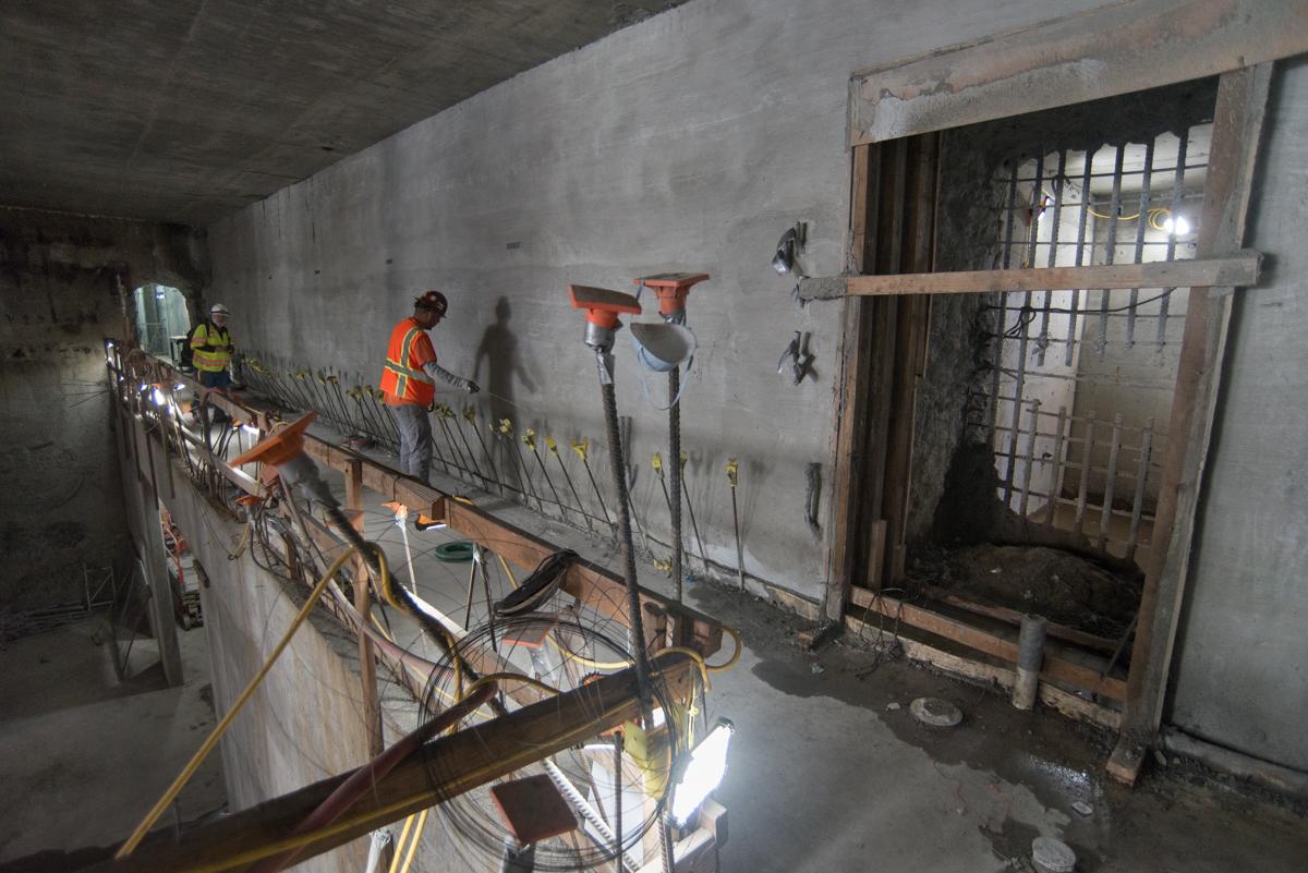 Workers assemble rebar cage on mezzanine level of Yerba Buena/Moscone Station headhouse construction site.