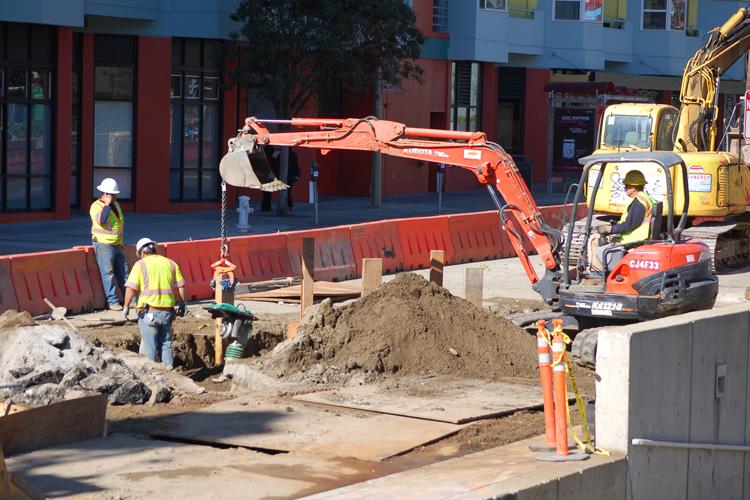 Construction crew operates excavator to install water line on 4th Street near future Yerba Buena/Moscone Station.