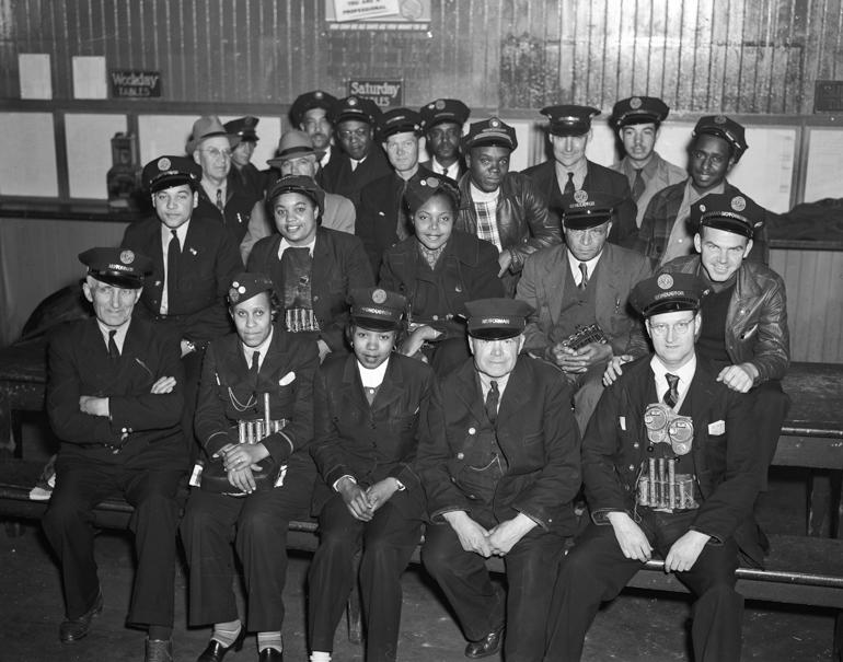 Group of Muni transit employees in uniforms posing at Sutro Carhouse, 1947.