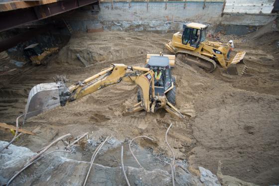 Excavation equipment and bulldozers working on 4th Street station headhouse construction site with dirt and debris.