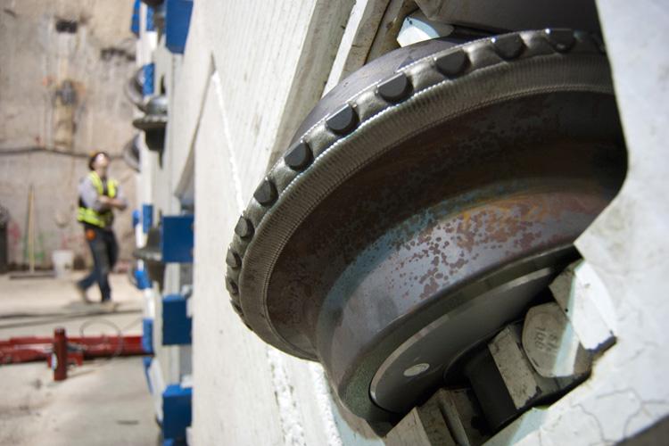 Close-up of a tunnel boring machine's cutting tooth with rust visible on the metal surface.