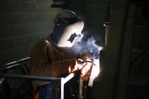 Welder performing metal work on station construction project
