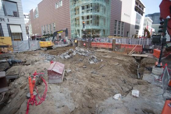 Construction excavation site at Union Square Market Street Station with heavy equipment and red safety markers.