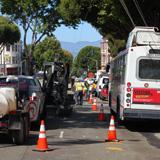 Construction work on Columbus Avenue with transit buses and equipment staged on street.